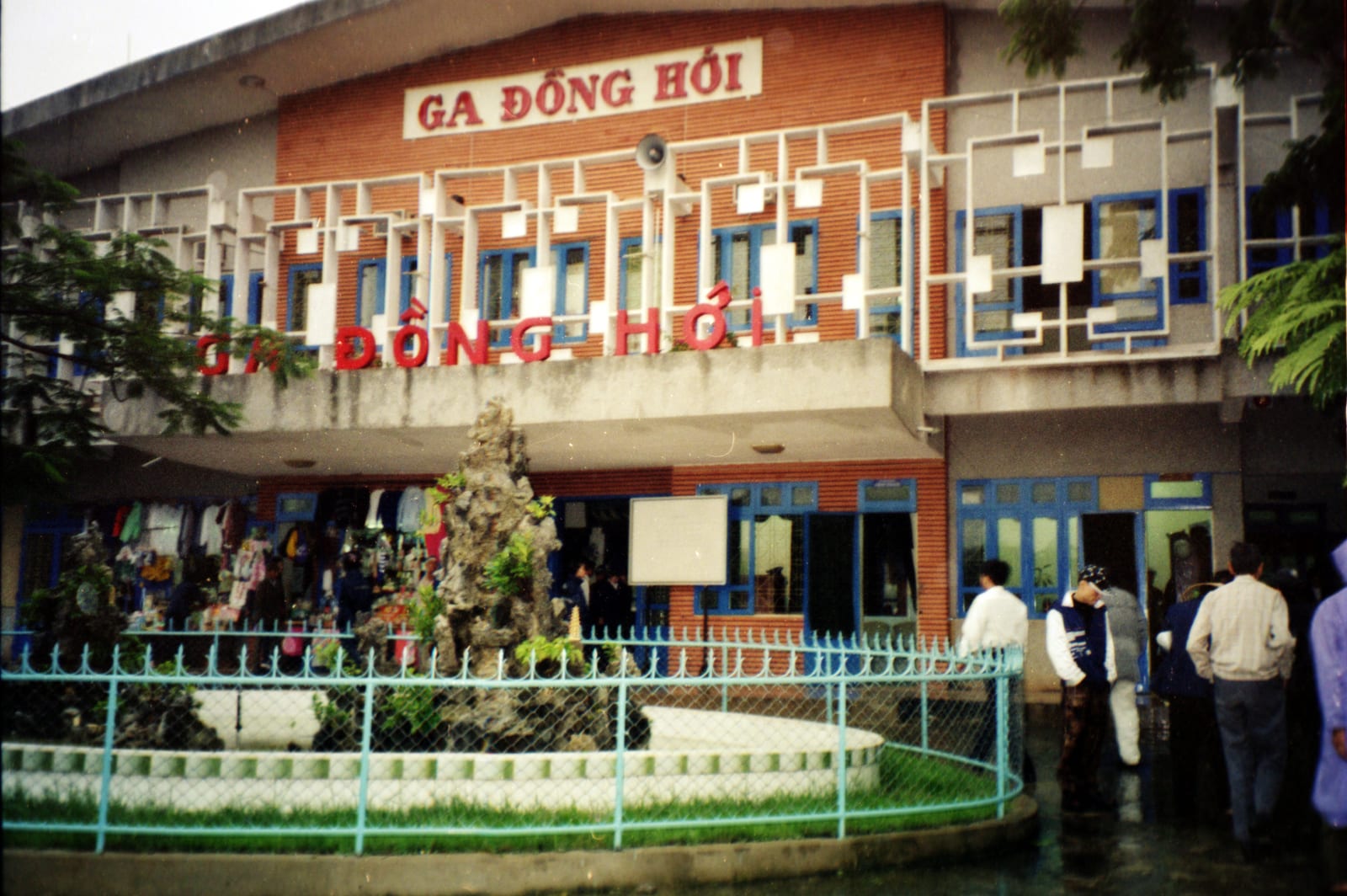 תחנת הרכבת של דונג הוי (Ga Đồng Hới) עם חזית כתומה ושלט התחנה